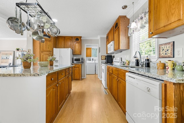 118 Grain Dr, Stony Point, NC 28678 - kitchen with white appliances, light wood-style flooring, brown cabinetry, ornamental molding, and a textured ceiling