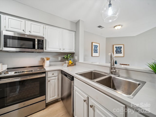 18817 Nautical Dr Unit 302, Cornelius, NC 28031 - kitchen with stainless steel appliances, white cabinetry, light countertops, and light wood finished floors