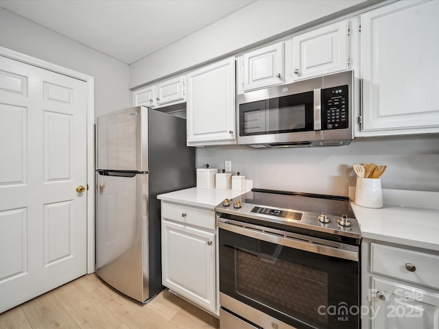 18817 Nautical Dr Unit 302, Cornelius, NC 28031 - kitchen with appliances with stainless steel finishes, light wood finished floors, white cabinetry, and light countertops