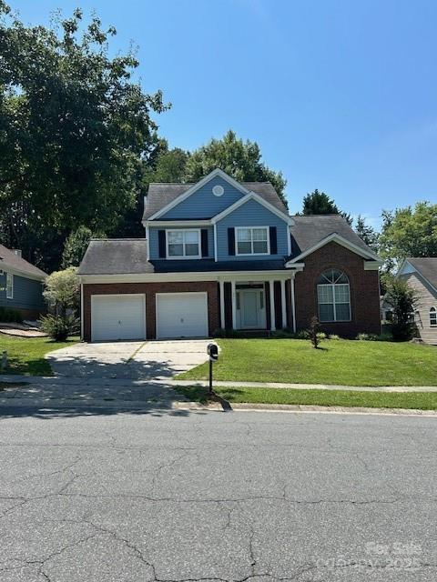 8901 Clifton Meadow Dr, Matthews, NC 28105 - view of front facade featuring a front yard, concrete driveway, and brick siding