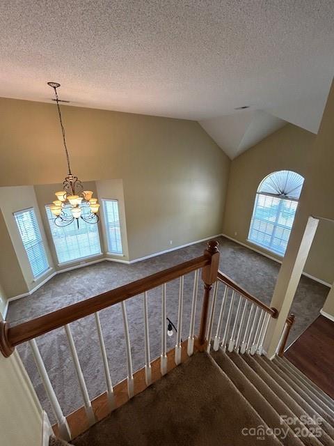8901 Clifton Meadow Dr, Matthews, NC 28105 - stairway featuring carpet flooring, vaulted ceiling, plenty of natural light, a chandelier, and a textured ceiling