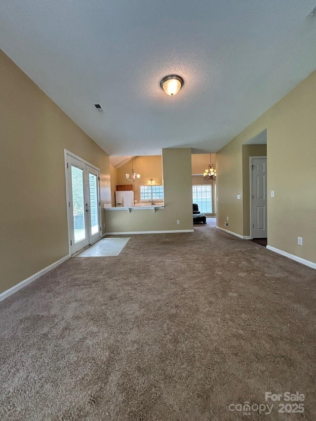 8901 Clifton Meadow Dr, Matthews, NC 28105 - unfurnished living room featuring a chandelier, carpet flooring, vaulted ceiling, and a textured ceiling