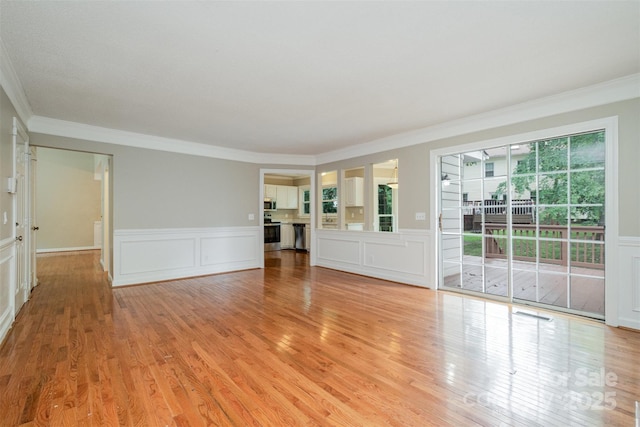 7114 Kinsmore Ln, Charlotte, NC 28269 - unfurnished living room with ornamental molding, light wood-style flooring, a decorative wall, and a wainscoted wall