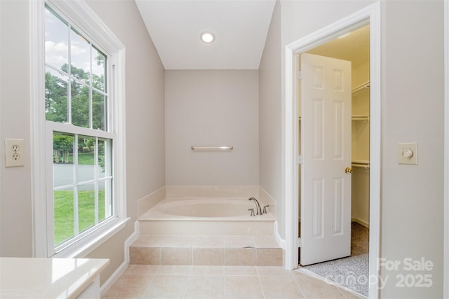 7114 Kinsmore Ln, Charlotte, NC 28269 - bathroom featuring a garden tub, a spacious closet, and tile patterned floors