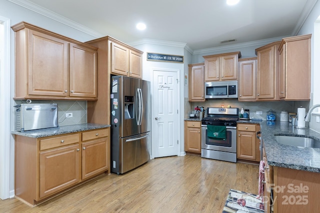 16142 Commodore Dr, Lancaster, SC 29720 - kitchen featuring stainless steel appliances, a sink, light wood-style flooring, dark stone countertops, and backsplash