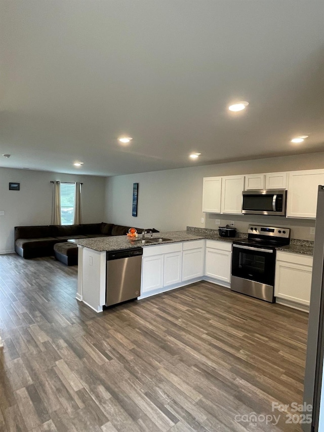 323 J C Dellinger Rd, Cherryville, NC 28021 - kitchen featuring stainless steel appliances, white cabinetry, dark wood-type flooring, a peninsula, and a sink