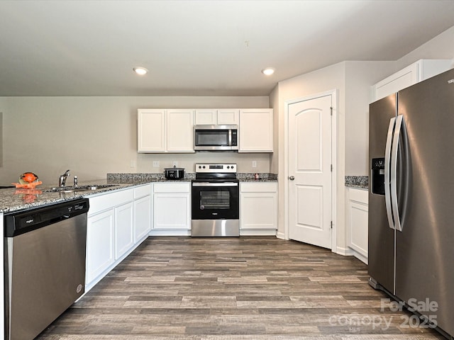 323 J C Dellinger Rd, Cherryville, NC 28021 - kitchen featuring appliances with stainless steel finishes, stone countertops, dark wood finished floors, white cabinets, and recessed lighting