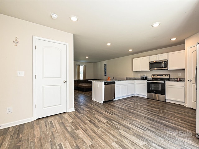 323 J C Dellinger Rd, Cherryville, NC 28021 - kitchen with appliances with stainless steel finishes, white cabinets, a peninsula, dark wood-type flooring, and recessed lighting