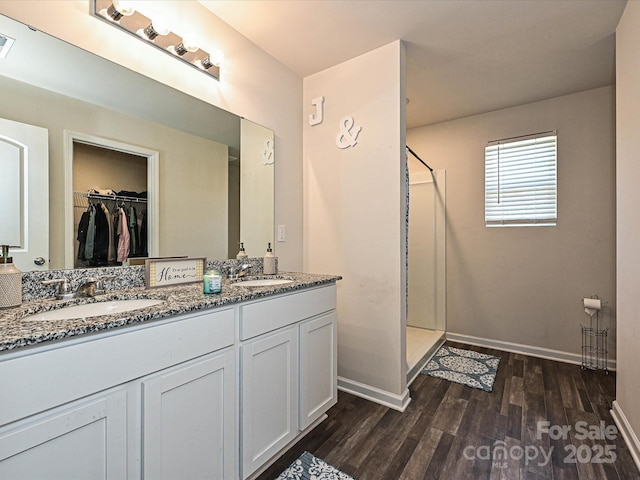 323 J C Dellinger Rd, Cherryville, NC 28021 - full bathroom featuring a stall shower, wood finished floors, double vanity, and a walk in closet