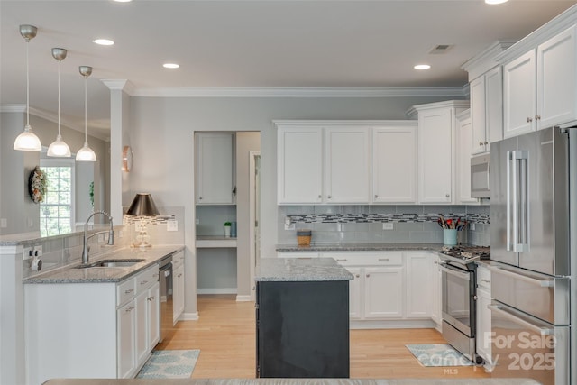 14727 Brannock Hills Dr, Charlotte, NC 28278 - kitchen featuring appliances with stainless steel finishes, a sink, tasteful backsplash, light wood finished floors, and white cabinetry