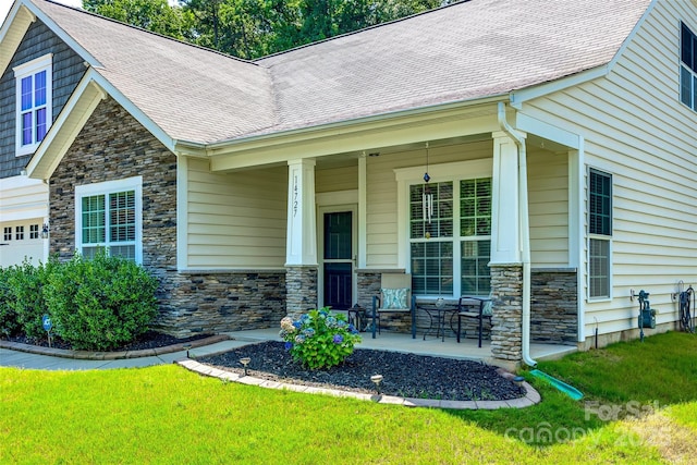 14727 Brannock Hills Dr, Charlotte, NC 28278 - doorway to property with a porch, stone siding, a yard, roof with shingles, and a garage