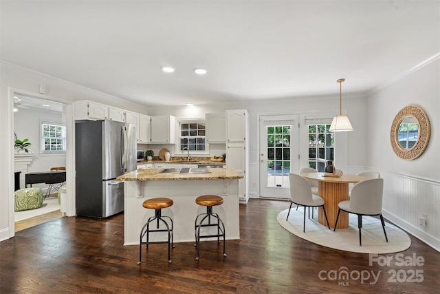 6938 Wrentree Dr, Charlotte, NC 28210 - kitchen with freestanding refrigerator, crown molding, white cabinetry, healthy amount of natural light, and light stone counters