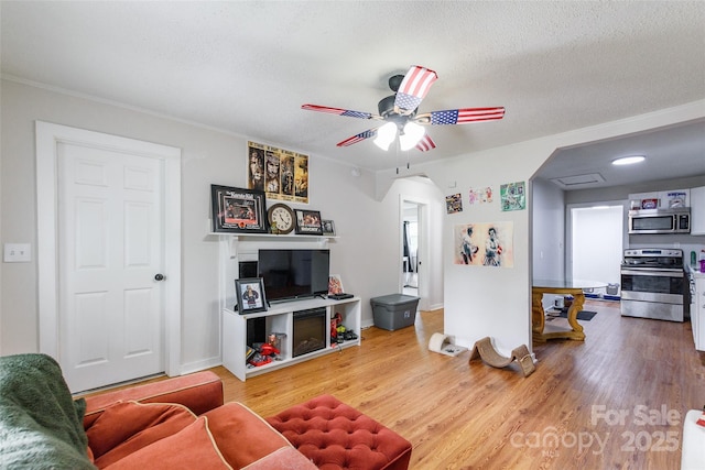 515 Myrtle Ave, Chester, SC 29706 - living area featuring arched walkways, wood finished floors, ceiling fan, a textured ceiling, and ornamental molding