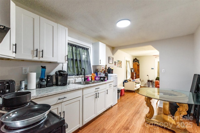 515 Myrtle Ave, Chester, SC 29706 - kitchen with a sink, white cabinetry, light countertops, light wood-style flooring, and a textured ceiling