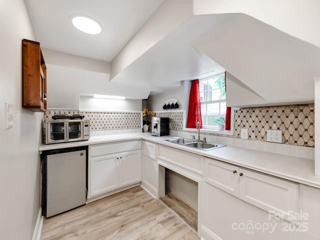 128 W End St, Chester, SC 29706 - kitchen featuring a sink, refrigerator, tasteful backsplash, white cabinets, and light wood-type flooring