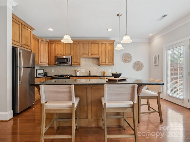 705 Congressional Ln, Fort Mill, SC 29708 - kitchen featuring appliances with stainless steel finishes, wood finished floors, ornamental molding, decorative backsplash, and a center island