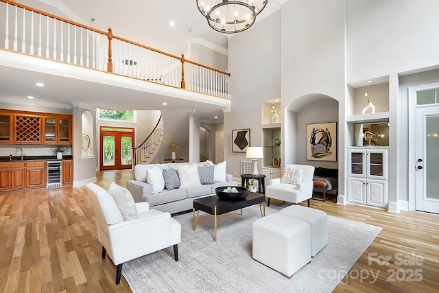 3324 Greenhurst Dr, Weddington, NC 28104 - living area featuring wine cooler, a towering ceiling, light wood-style floors, bar with sink, and built in features