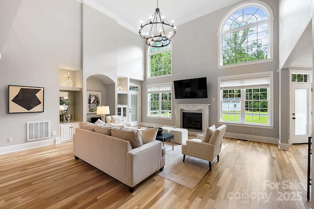 3324 Greenhurst Dr, Weddington, NC 28104 - living room with baseboards, built in features, light wood-style floors, a premium fireplace, and a towering ceiling