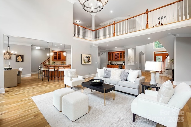 3324 Greenhurst Dr, Weddington, NC 28104 - living room with a high ceiling, stairs, baseboards, arched walkways, and light wood-type flooring