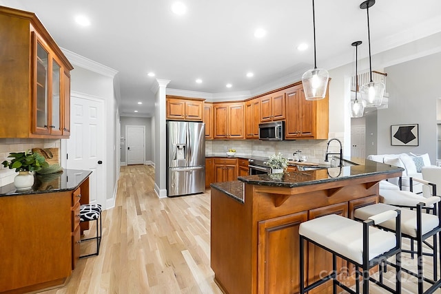 3324 Greenhurst Dr, Weddington, NC 28104 - kitchen with appliances with stainless steel finishes, brown cabinets, a peninsula, ornamental molding, and light wood-type flooring