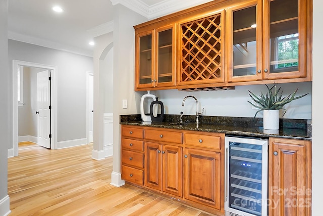 3324 Greenhurst Dr, Weddington, NC 28104 - indoor wet bar with wine cooler, crown molding, light wood-type flooring, baseboards, and arched walkways