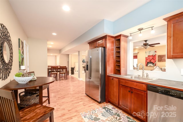 133 Upland Dr, Statesville, NC 28625 - kitchen with stainless steel appliances, a sink, a ceiling fan, light wood finished floors, and brown cabinetry