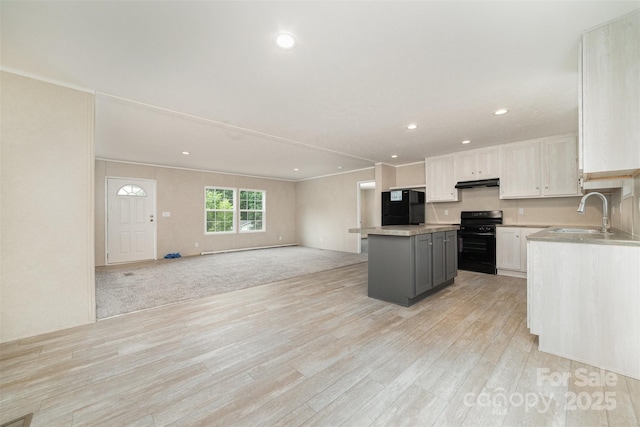 5090 Beaver Dam Way, Bessemer City, NC 28016 - kitchen featuring black range, a sink, fridge, a kitchen island, and light wood-style flooring