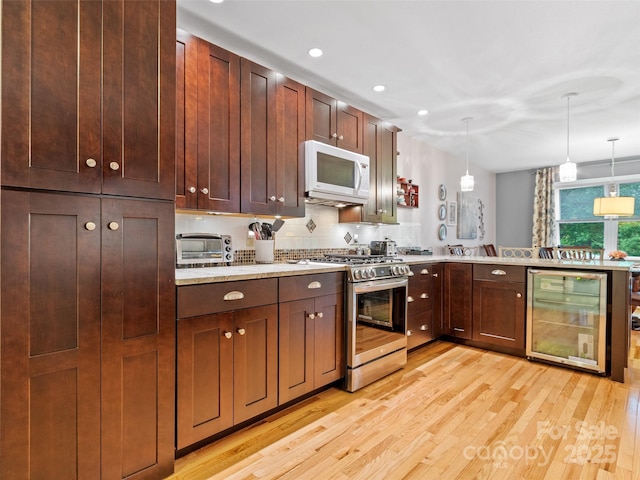 138 Down To Earth Dr, Burnsville, NC 28714 - kitchen featuring beverage cooler, gas stove, white microwave, light wood finished floors, and light countertops