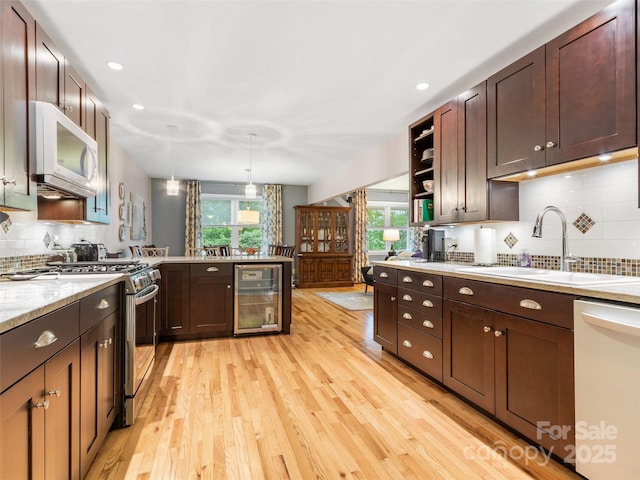 138 Down To Earth Dr, Burnsville, NC 28714 - kitchen featuring dishwasher, stainless steel gas range, wine cooler, white microwave, and a sink