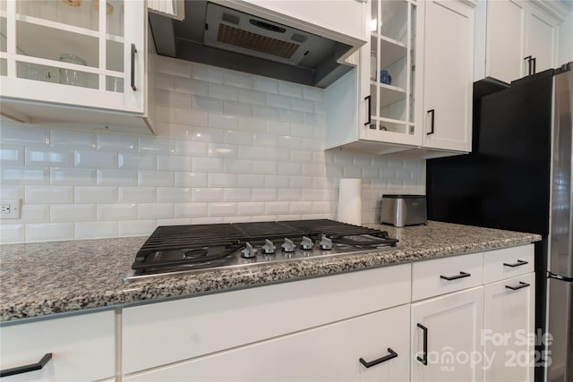 1906 Pensco Pond Ct, Waxhaw, NC 28173 - kitchen with range hood, stainless steel gas cooktop, tasteful backsplash, white cabinets, and light stone countertops