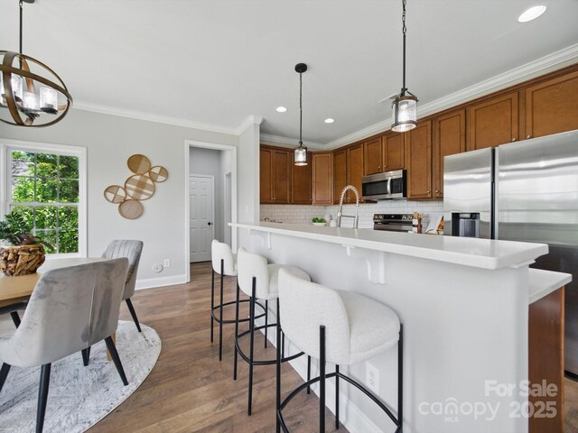 8304 Prescott Glen Pkwy, Waxhaw, NC 28173 - kitchen with appliances with stainless steel finishes, light countertops, ornamental molding, dark wood-type flooring, and decorative backsplash