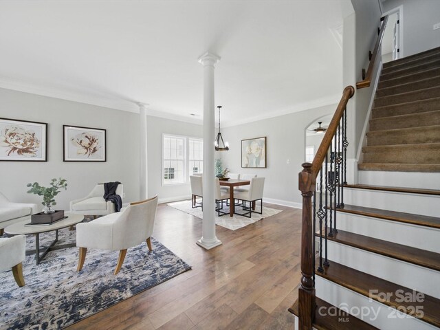 8304 Prescott Glen Pkwy, Waxhaw, NC 28173 - living area featuring decorative columns, crown molding, stairway, wood finished floors, and baseboards