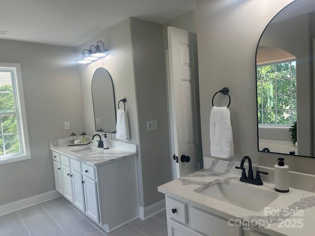 8304 Prescott Glen Pkwy, Waxhaw, NC 28173 - bathroom featuring baseboards, two vanities, plenty of natural light, and tile patterned floors