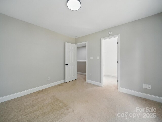 8304 Prescott Glen Pkwy, Waxhaw, NC 28173 - unfurnished bedroom with a spacious closet, light carpet, baseboards, and a closet