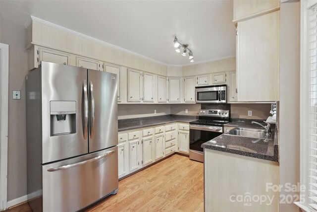 1517 E Barden Rd, Charlotte, NC 28226 - kitchen featuring appliances with stainless steel finishes, light wood-type flooring, ornamental molding, and dark stone countertops