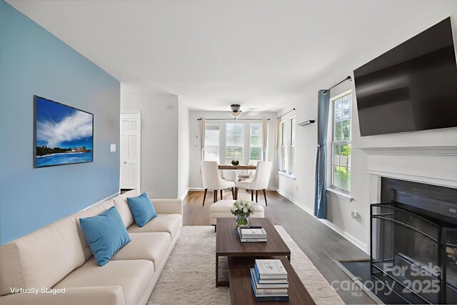 6516 Laurel Springs Ct, Charlotte, NC 28227 - living room featuring a fireplace with flush hearth, wood finished floors, and baseboards
