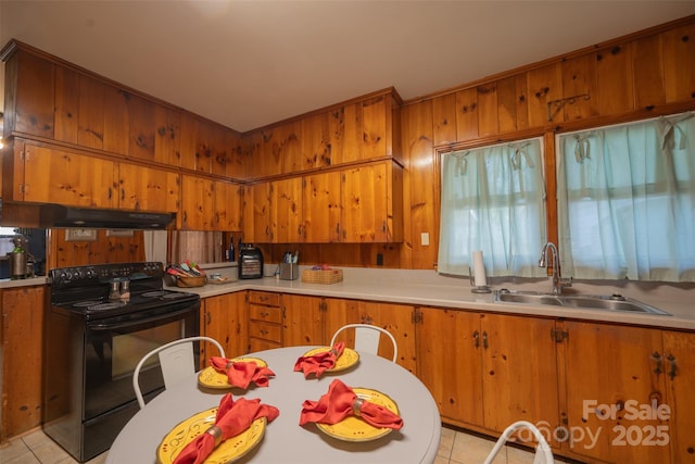 100 S Rudisill Ave, Cherryville, NC 28021 - kitchen with black electric range, a sink, under cabinet range hood, light tile patterned flooring, and brown cabinets