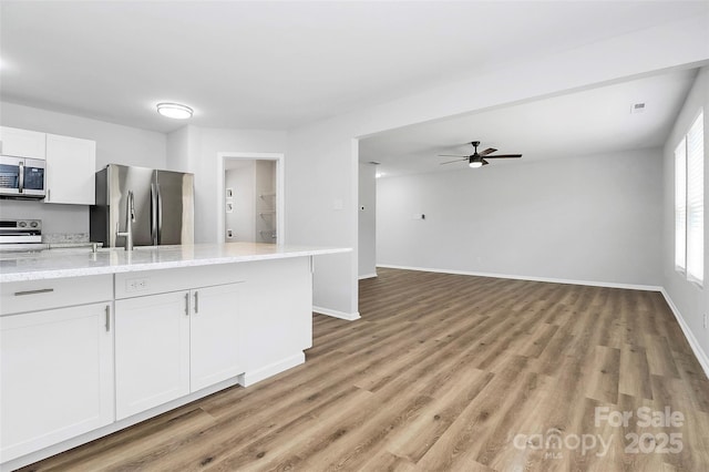7214 Fox Point Dr, Charlotte, NC 28269 - kitchen featuring stainless steel appliances, a ceiling fan, light wood finished floors, baseboards, and white cabinets