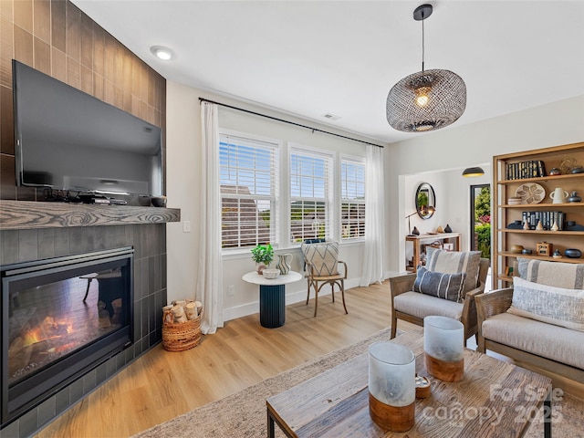 218 Water Leaf Dr, Weaverville, NC 28787 - living room with a tiled fireplace, light wood-type flooring, and baseboards