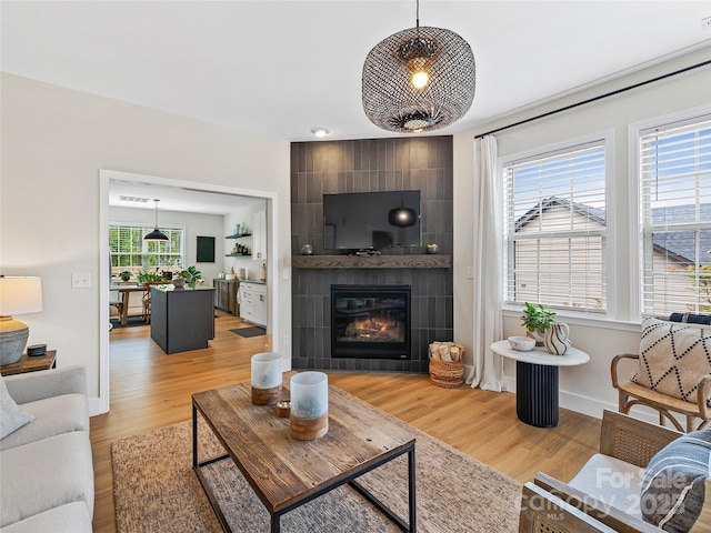 218 Water Leaf Dr, Weaverville, NC 28787 - living area featuring light wood-type flooring, a tiled fireplace, and baseboards