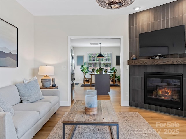 218 Water Leaf Dr, Weaverville, NC 28787 - living room with light wood-style floors, a large fireplace, and baseboards