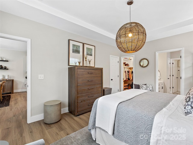 218 Water Leaf Dr, Weaverville, NC 28787 - bedroom with light wood-style floors, a spacious closet, baseboards, and ensuite bathroom