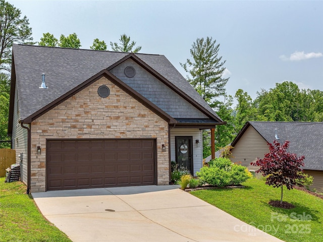 218 Water Leaf Dr, Weaverville, NC 28787 - view of front facade with stone siding, concrete driveway, a shingled roof, a garage, and a front yard