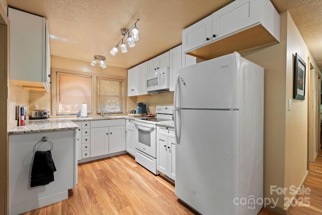 139 Ivy Ridge Church Rd, Mars Hill, NC 28754 - kitchen with white appliances, a textured ceiling, light wood-style flooring, white cabinets, and light stone countertops