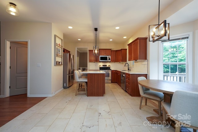 2908 Barnard Castle Ln, Matthews, NC 28104 - kitchen with appliances with stainless steel finishes, a kitchen bar, light countertops, a sink, and a chandelier