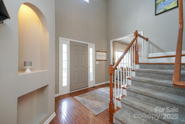 2908 Barnard Castle Ln, Matthews, NC 28104 - entrance foyer featuring hardwood / wood-style floors, arched walkways, stairs, a high ceiling, and baseboards
