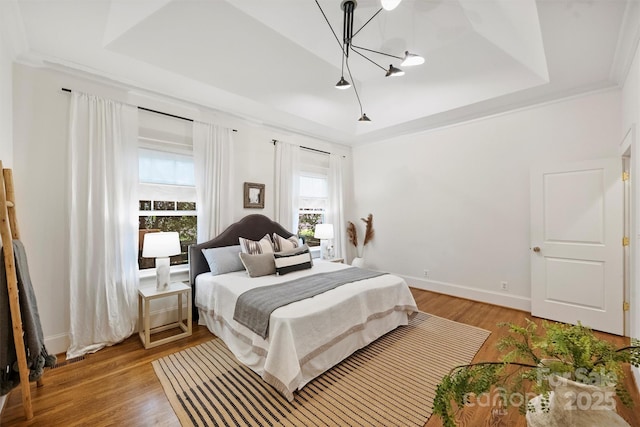 1417 The Plz, Charlotte, NC 28205 - bedroom featuring a tray ceiling, a chandelier, and light wood-style floors