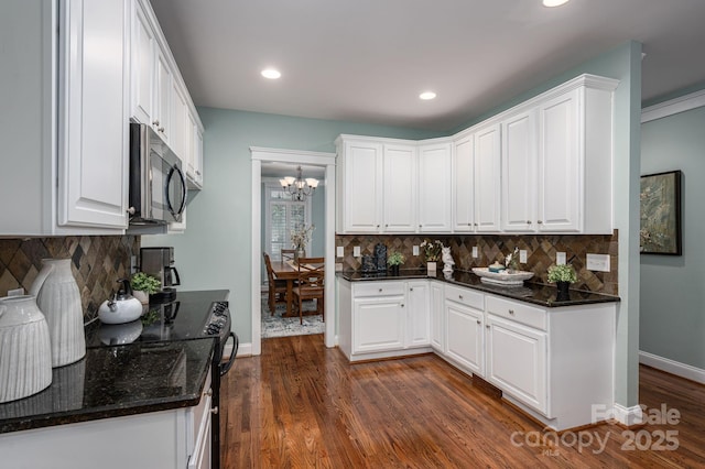 506 Academy St, Mcadenville, NC 28101 - kitchen featuring a chandelier, black range with electric cooktop, white cabinetry, backsplash, and dark wood-style floors