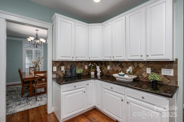 506 Academy St, Mcadenville, NC 28101 - kitchen with a chandelier, decorative backsplash, white cabinets, dark wood finished floors, and dark stone countertops