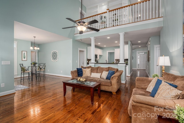 506 Academy St, Mcadenville, NC 28101 - living room featuring a towering ceiling, ornate columns, dark wood-style flooring, a ceiling fan, and baseboards
